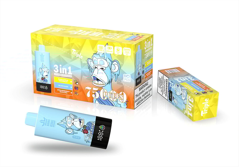 A Colorful Packaging Box For A Vaping Product Featuring A Cartoon Monkey, Labeled '3 In 1' With Flavors 'Pineapple Coconut', 'Blue Razz', And 'Strawberry Banana', Alongside Details Including '75 Puffs' And Warning Information; A Vape Stick In Light Blue With The Monkey Design Is Prominently Displayed In Front.