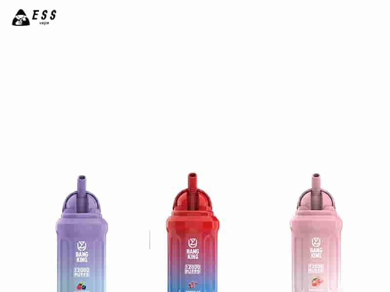 Tres dispositivos de vapeo desechables en colores morado, rojo y rosa, etiquetados como "Bang King" con diferentes sabores: arándano, cereza helada y melocotón, cada uno ofrece 12.000 bocanadas.