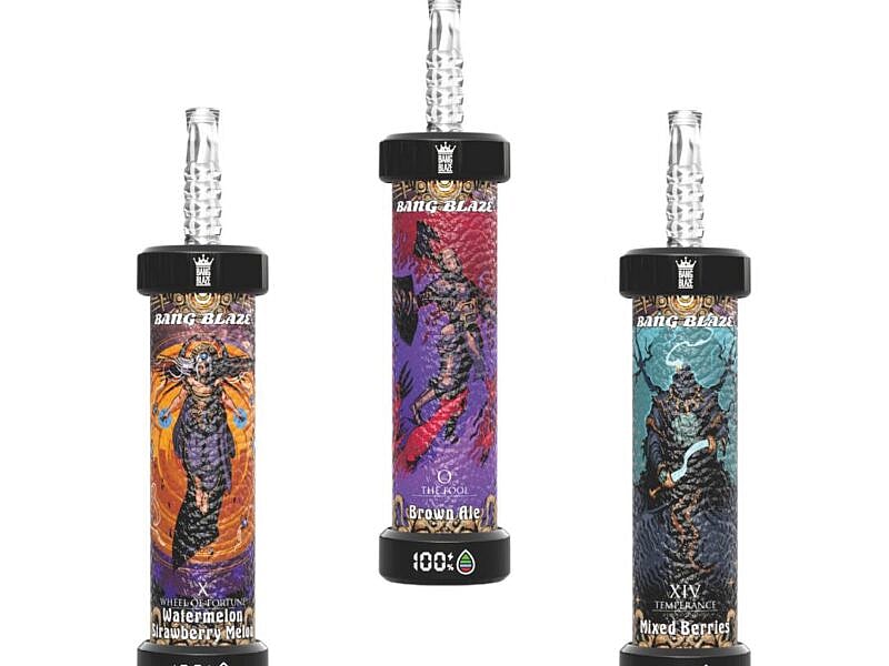 Three vape devices from Bang Blaze, featuring colorful designs: the left device has a 'Wheel of Fortune' motif with watermelon and strawberry melon flavor, the center device labeled 'Brown Ale' in purple, and the right device decorated with a 'Temperance' theme showcasing mixed berries, all with transparent mouthpieces.